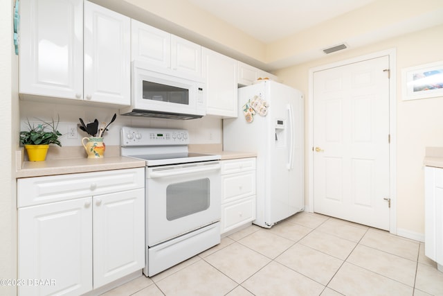 kitchen with white cabinets, white appliances, and light tile patterned floors