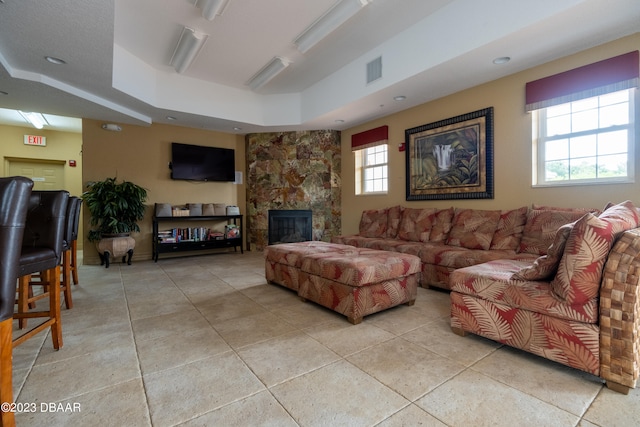 living room with a fireplace and a raised ceiling