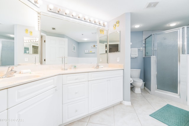 bathroom featuring toilet, an enclosed shower, vanity, and tile patterned floors