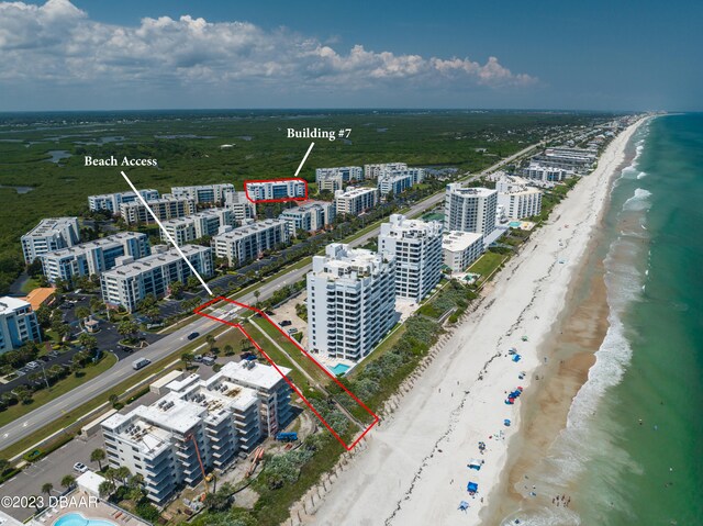 drone / aerial view with a beach view and a water view