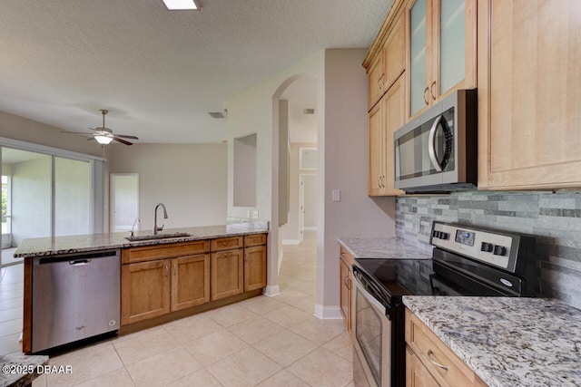 1832 Afshin Ct, Port Orange, FL 32128 - kitchen featuring appliances with stainless steel finishes, a peninsula, light stone countertops, arched walkways, and a textured ceiling