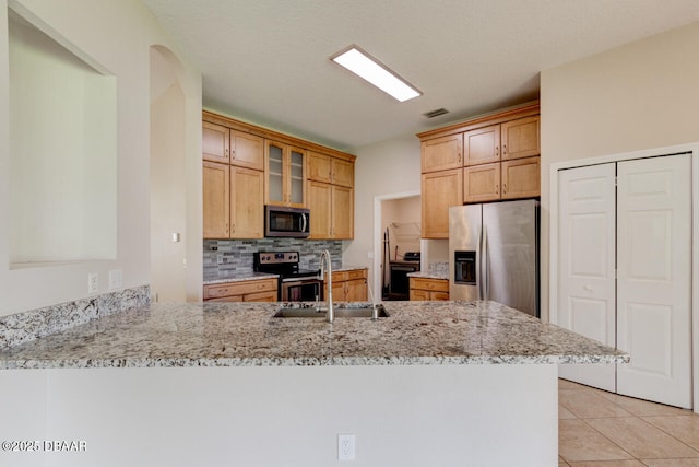 1832 Afshin Ct, Port Orange, FL 32128 - kitchen with stainless steel appliances, a peninsula, backsplash, glass insert cabinets, and light stone countertops