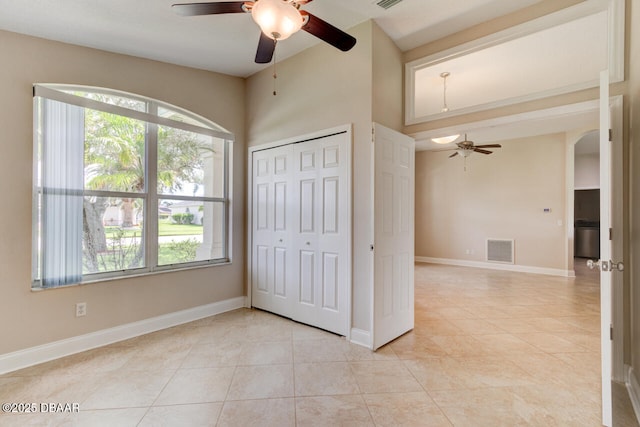 1832 Afshin Ct, Port Orange, FL 32128 - unfurnished bedroom with light tile patterned floors, arched walkways, a closet, and ceiling fan