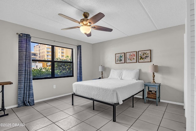 3800 S S Atlantic Ave Unit 105, Daytona Beach Shores, FL 32118 - bedroom with light tile patterned flooring, baseboards, a textured ceiling, and a ceiling fan
