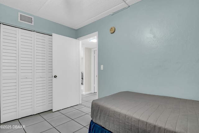 3800 S S Atlantic Ave Unit 105, Daytona Beach Shores, FL 32118 - bedroom with light tile patterned floors, a closet, and a textured ceiling