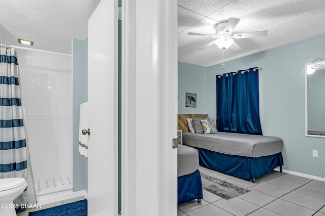 3800 S S Atlantic Ave Unit 105, Daytona Beach Shores, FL 32118 - bathroom featuring a stall shower, toilet, ceiling fan, tile patterned flooring, and baseboards