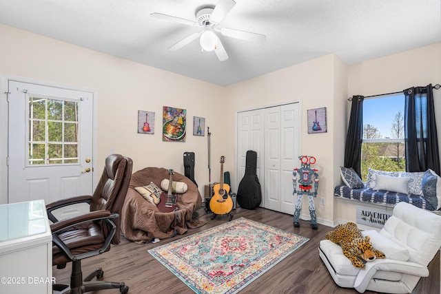 office featuring a ceiling fan, wood finished floors, and baseboards