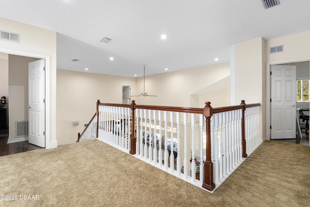 corridor with recessed lighting, visible vents, and an upstairs landing