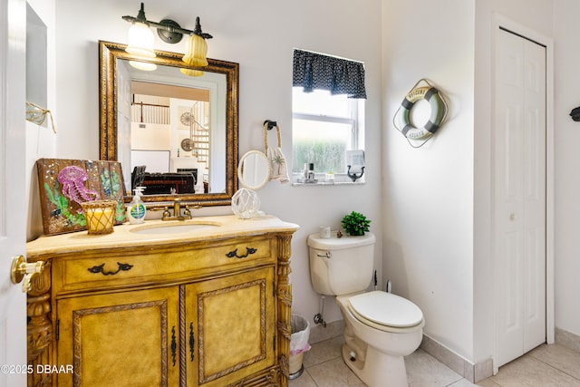 bathroom featuring toilet, a closet, tile patterned flooring, baseboards, and vanity