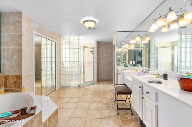 bathroom with a textured ceiling, tile walls, a stall shower, and tile patterned flooring