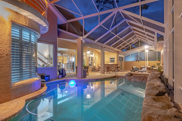 view of swimming pool with a patio area, glass enclosure, a jacuzzi, and a fenced in pool