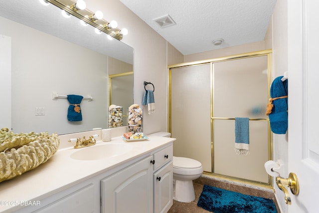 full bath featuring visible vents, toilet, a textured ceiling, a shower stall, and vanity