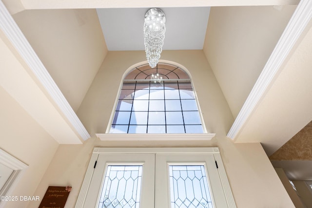 interior details with french doors and a notable chandelier