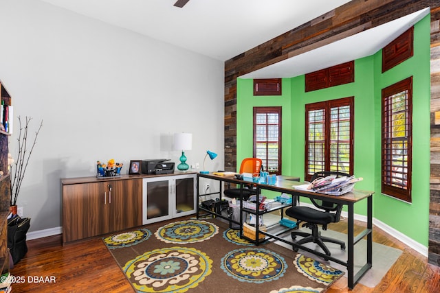 office featuring baseboards, beam ceiling, and wood finished floors