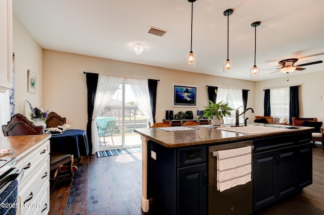 kitchen with open floor plan, dark cabinetry, and visible vents