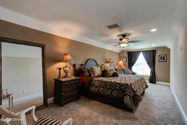 bedroom featuring visible vents, baseboards, light colored carpet, vaulted ceiling, and a textured ceiling