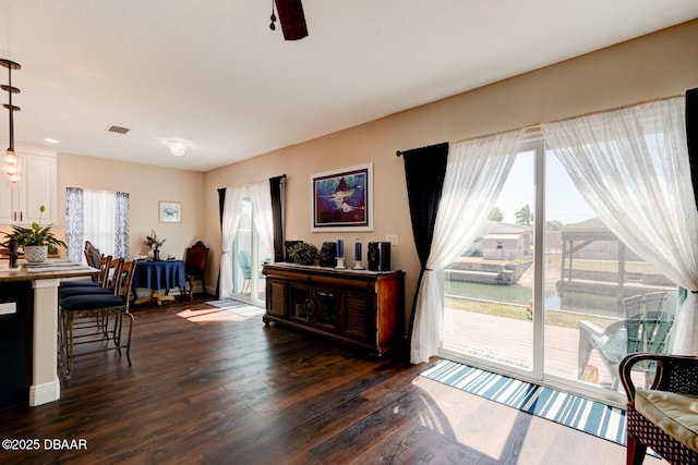 interior space featuring ceiling fan, visible vents, and dark wood finished floors