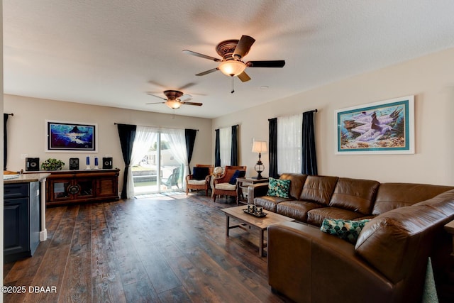 living area with a textured ceiling, dark wood-style floors, and a ceiling fan