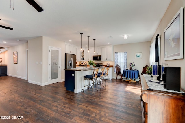 kitchen featuring dark wood finished floors, white cabinets, a ceiling fan, and appliances with stainless steel finishes