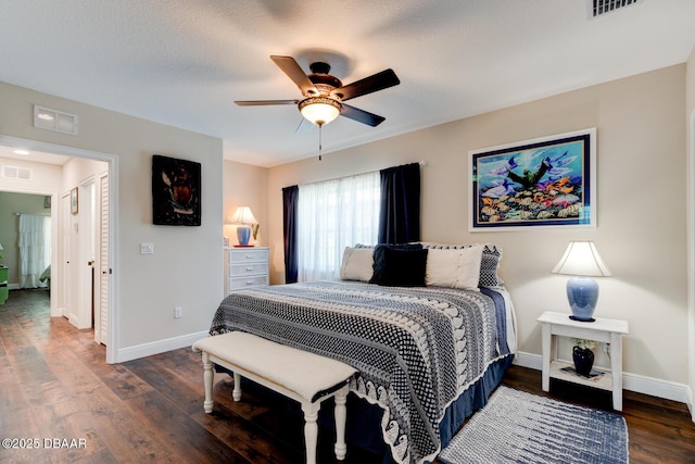 bedroom with wood finished floors, visible vents, and baseboards