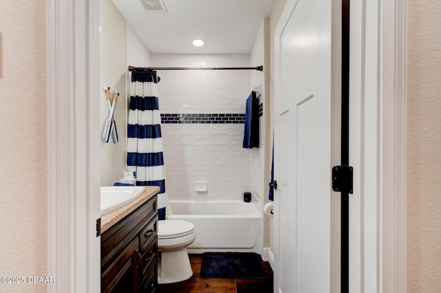 bathroom with visible vents, toilet, shower / bath combo with shower curtain, wood finished floors, and vanity