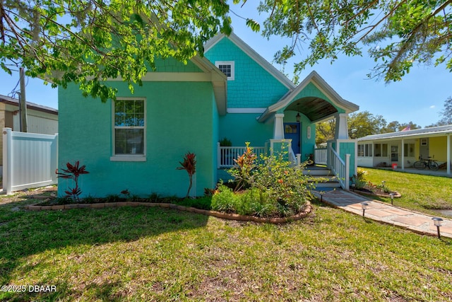 view of front of house featuring a porch, a front lawn, and fence