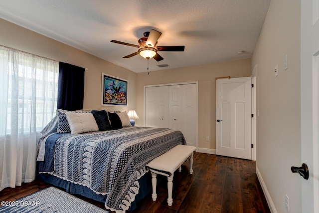 bedroom featuring a ceiling fan, wood finished floors, baseboards, visible vents, and a closet