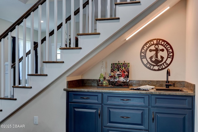 bar featuring stairway, wet bar, and a sink