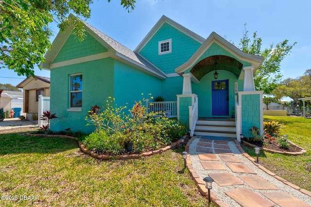 view of front of house with covered porch and a front yard