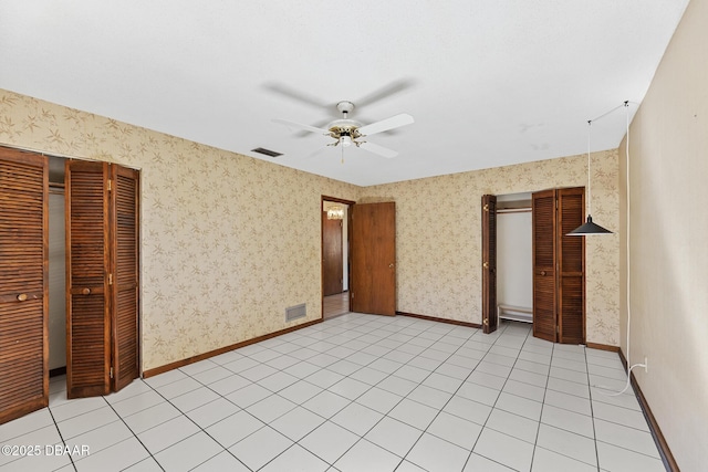 unfurnished bedroom with light tile patterned floors, ceiling fan, and a closet