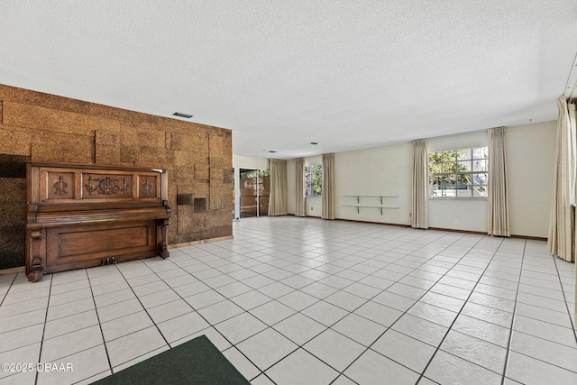 living room featuring a textured ceiling and light tile patterned floors