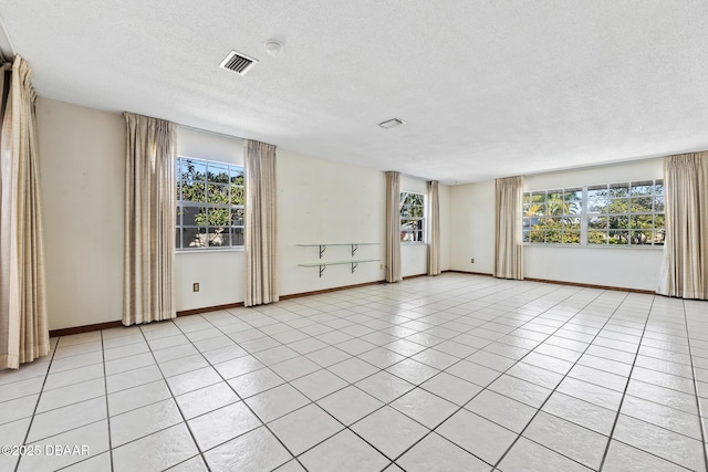 unfurnished room featuring light tile patterned floors and a textured ceiling