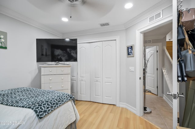 bedroom featuring light wood-type flooring, a closet, crown molding, and ceiling fan