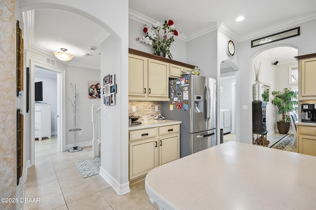 kitchen with cream cabinetry, light tile patterned floors, stainless steel refrigerator with ice dispenser, and tasteful backsplash