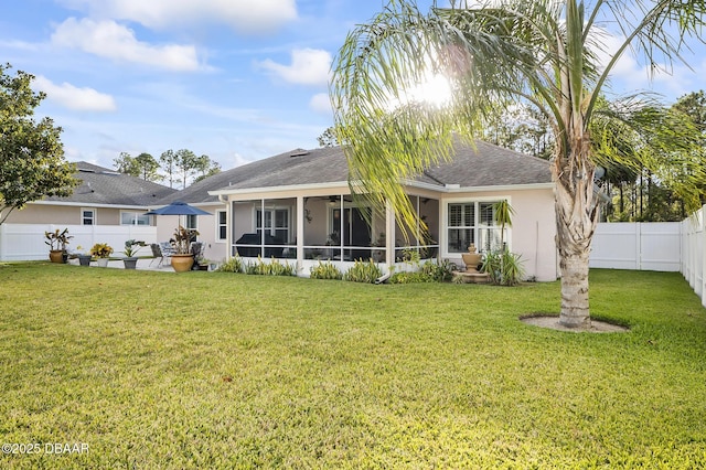 back of property with a lawn and a sunroom