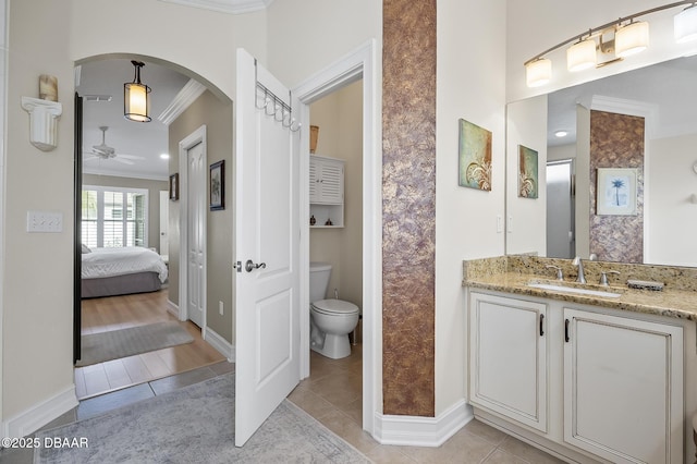 bathroom with vanity, tile patterned flooring, ceiling fan, toilet, and ornamental molding