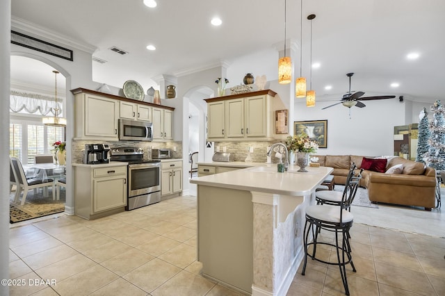 kitchen featuring sink, ceiling fan, decorative light fixtures, kitchen peninsula, and stainless steel appliances