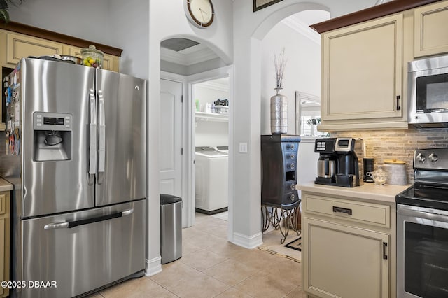 kitchen with light tile patterned flooring, appliances with stainless steel finishes, and cream cabinets