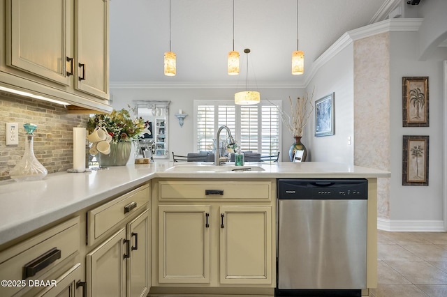 kitchen with cream cabinetry, stainless steel dishwasher, hanging light fixtures, and sink