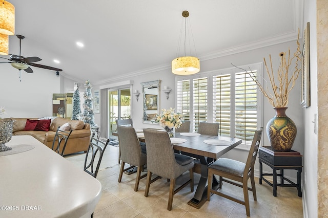 tiled dining space with ceiling fan, crown molding, and vaulted ceiling