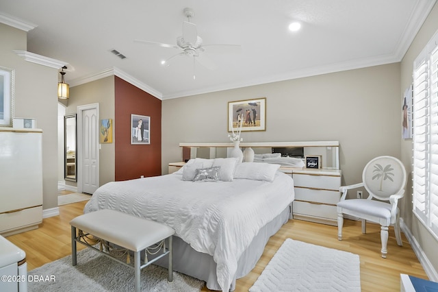 bedroom featuring light hardwood / wood-style floors, ceiling fan, and ornamental molding