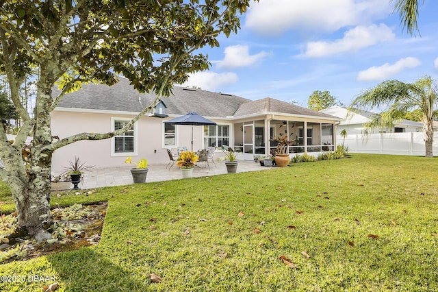 back of property with a patio area, a sunroom, and a yard