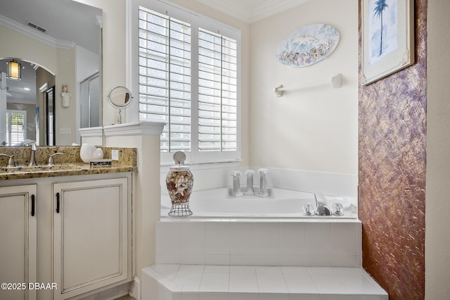 bathroom with a relaxing tiled tub, crown molding, and vanity