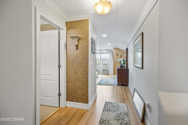 hallway with crown molding, lofted ceiling, and light wood-type flooring