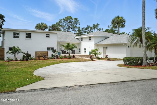 5540 W Bayshore Dr, Port Orange, FL 32127 - view of front of property with stucco siding, a front lawn, driveway, an attached garage, and roof with shingles