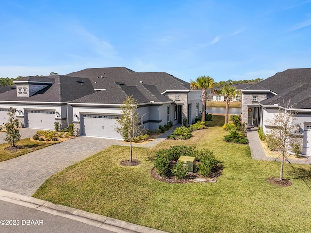 view of front of house with a garage, a water view, and a front yard