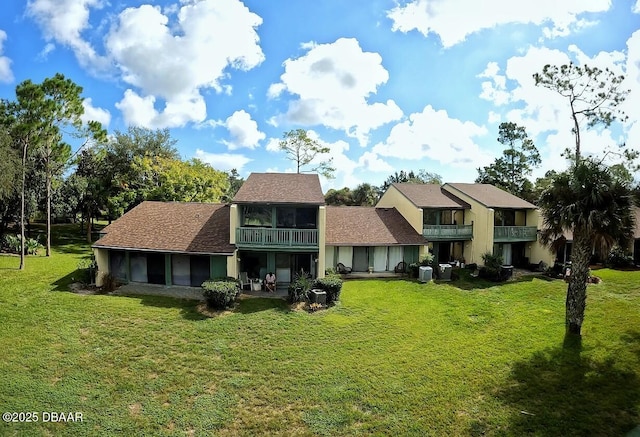 219 Club House Blvd Unit 219, New Smyrna Beach, FL 32168 - rear view of house with a sunroom, a yard, and a balcony