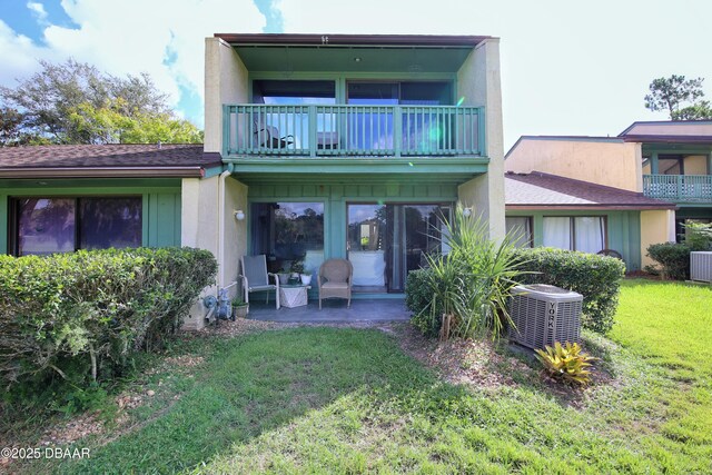 219 Club House Blvd Unit 219, New Smyrna Beach, FL 32168 - back of property featuring a balcony, central air condition unit, a yard, and stucco siding