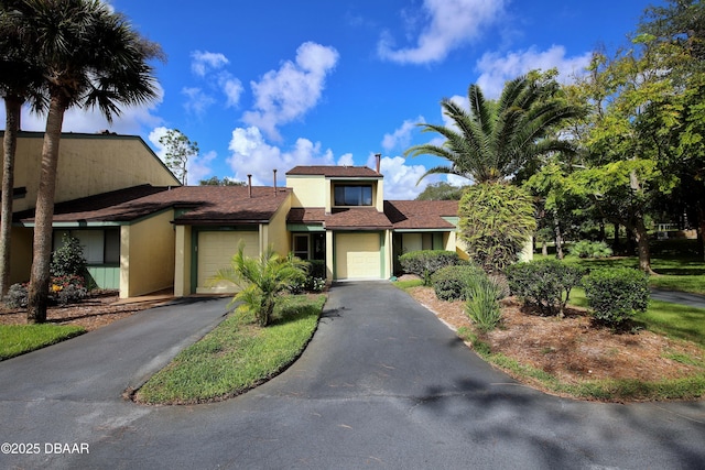 219 Club House Blvd Unit 219, New Smyrna Beach, FL 32168 - view of front facade with asphalt driveway, stucco siding, a garage, and a shingled roof