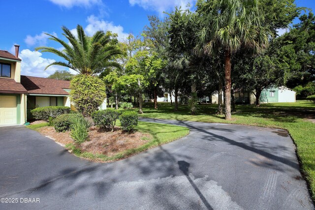 219 Club House Blvd Unit 219, New Smyrna Beach, FL 32168 - view of grassy yard with driveway and a garage